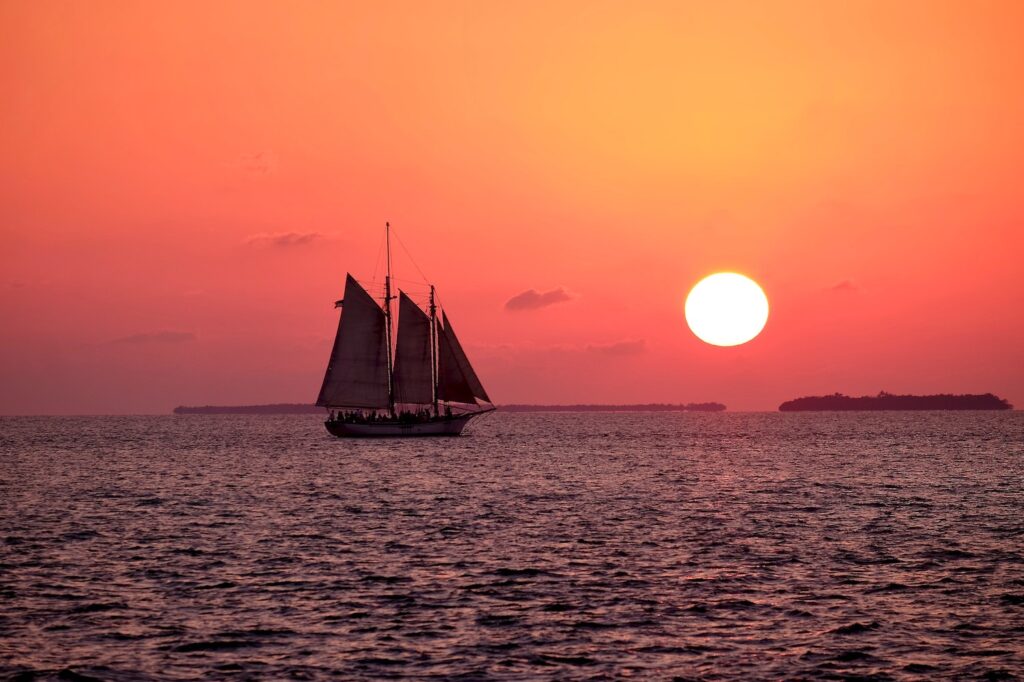 Sailboat on the ocean, with the sunset in the background.Peace chaos indian writer author